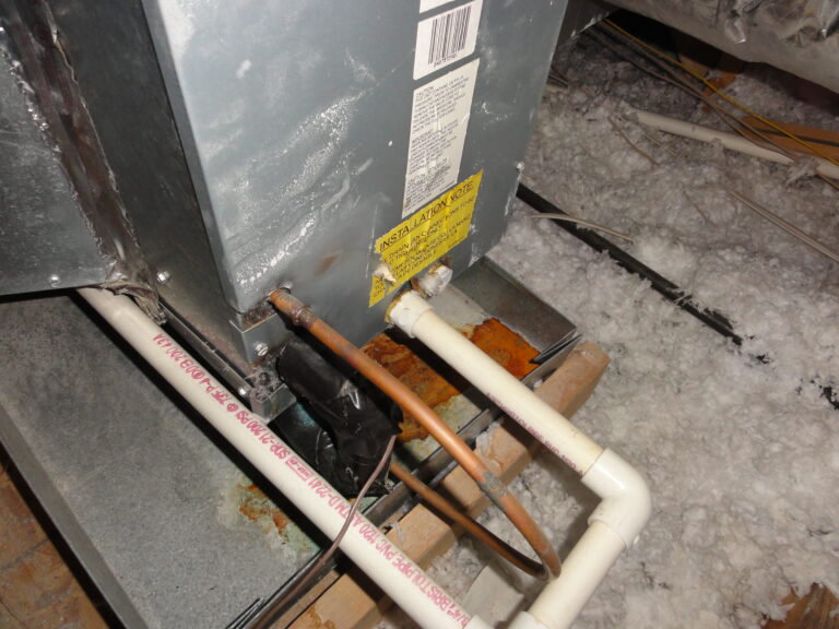 Close-up of HVAC system with pipes and warning label.