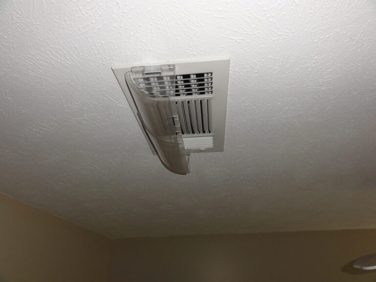 Ceiling vent with damaged and hanging plastic cover.