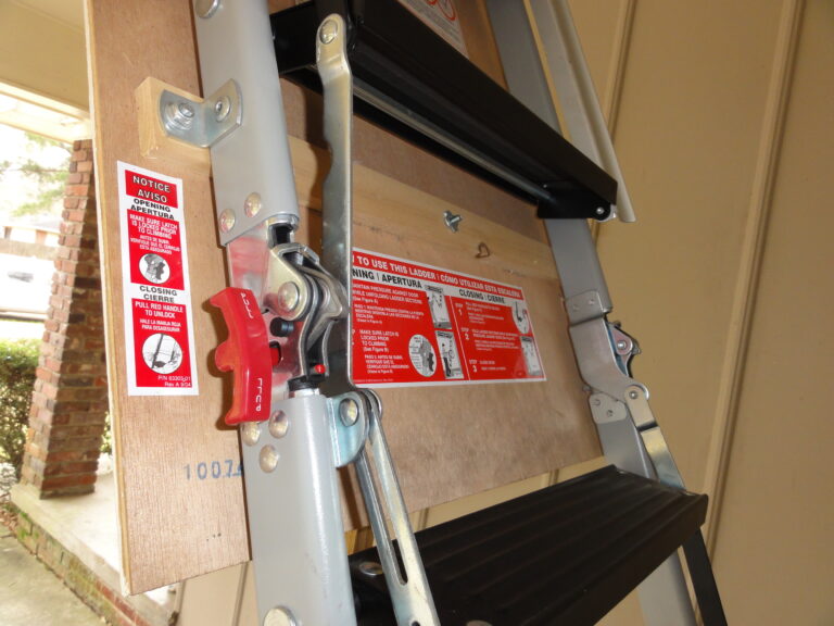 Close-up of a hand-operated pallet jack lifting a wooden pallet.