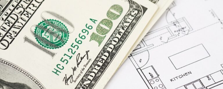 Close-up of hundred-dollar bills on technical drawings.