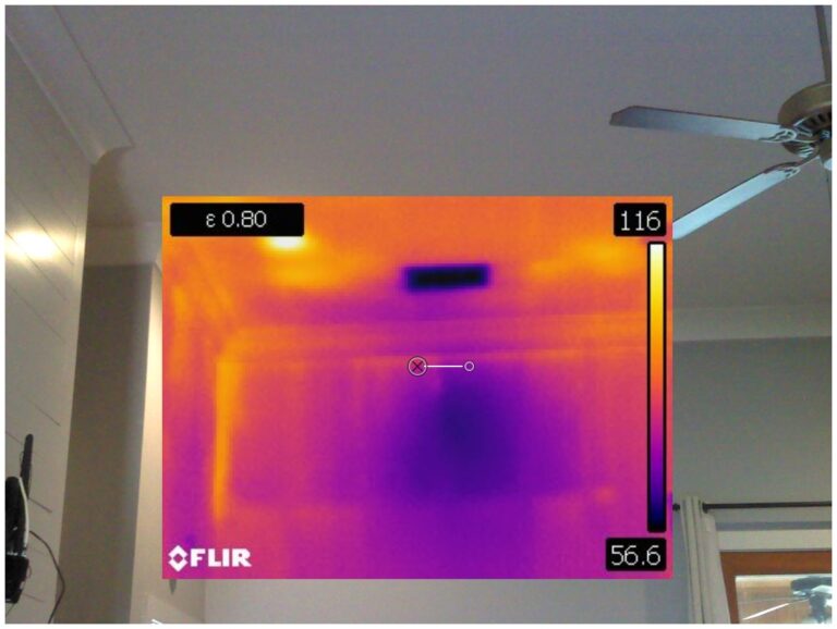 Thermal image showing heat distribution on a wall with a cooler rectangular area.