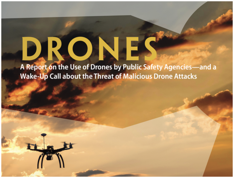 Drone flying over a city with a dramatic sunset sky.