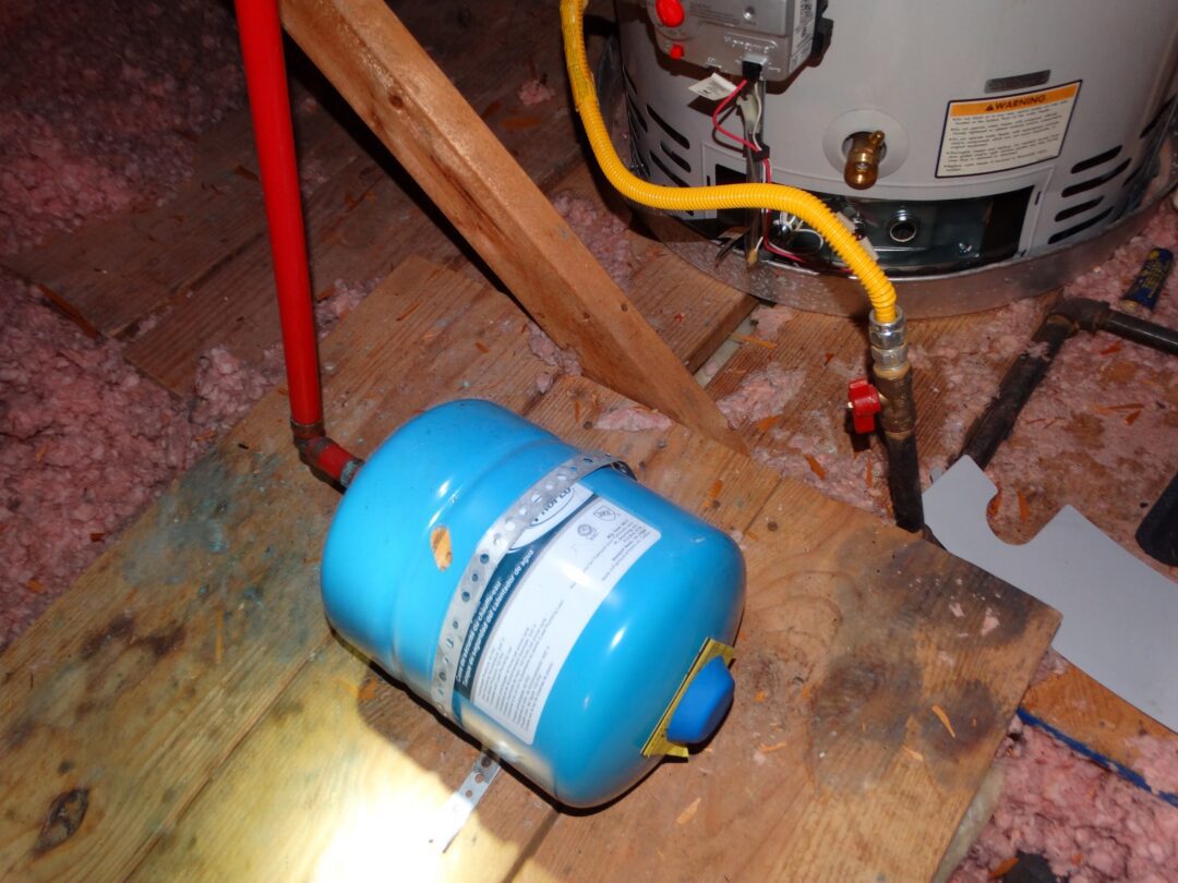 A thermal expansion tank installed in an attic without protecting the building from potential leaks.