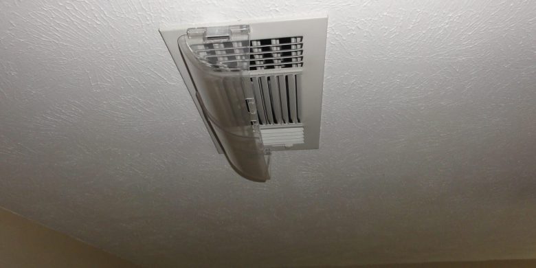 Ceiling vent with damaged and hanging plastic cover.